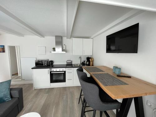a kitchen with a table and chairs and a kitchen with a tv at Juna in Laboe