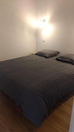 a bed in a white room with aigiligiligiligil at Les loges in Parthenay