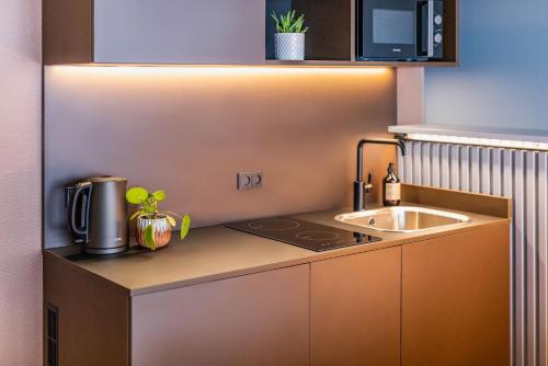 a small kitchen with a sink and a microwave at Pier 5 Hotel in Aalborg