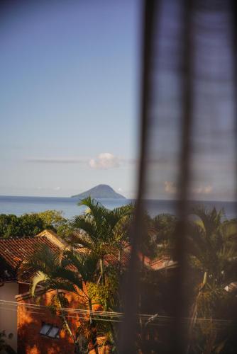 a view of the ocean from a building with palm trees at Øko Villa in Juquei
