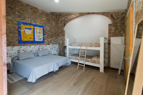 a bedroom with two beds and a stone wall at Cal Rajoler in Cabanes