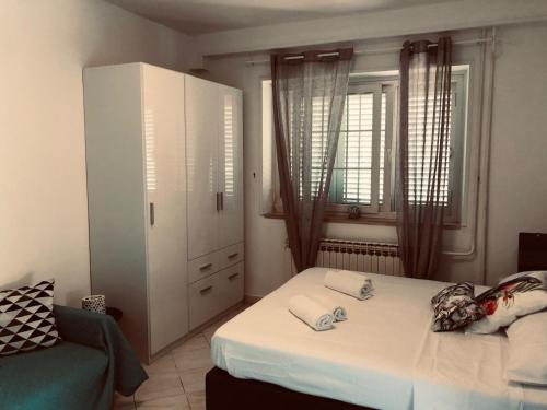a bedroom with a bed and a cabinet and a chair at Flower House - Lapad in Dubrovnik