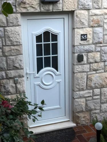 a white door on a stone house at Flower House - Lapad in Dubrovnik