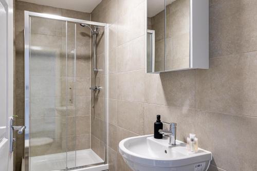 a bathroom with a sink and a shower at Top Floor Apartment with Private Balcony in Stockport Centre by HASS HAUS in Stockport