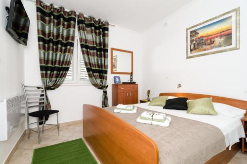 1 dormitorio con 1 cama con 2 toallas en Apartment and Room Kapelica, en Dubrovnik