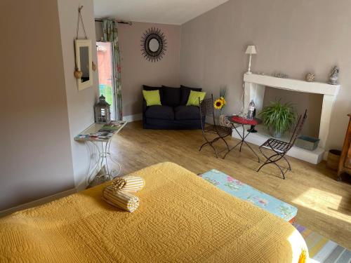 een woonkamer met een bank en een tafel bij La Charaudière in Champtoceaux