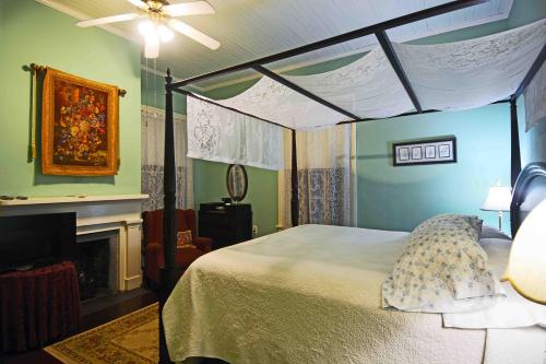 a bedroom with a canopy bed and a fireplace at 1872 Denham Inn in Monticello