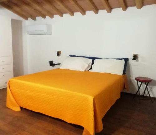 1 dormitorio con 1 cama con manta naranja en Agriturismo Fattoria le caprine en Gambassi Terme
