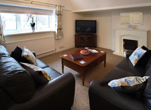 a living room with two couches and a coffee table at Beachside Suites in Minehead