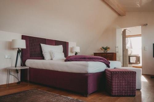 a bedroom with a large bed with a purple headboard at Winkel Art Hotel in Gamlitz