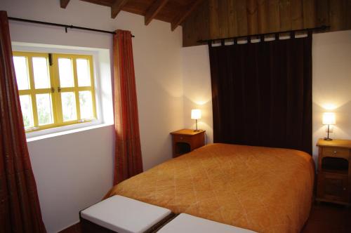 a bedroom with a bed and a window at Monte da Gravita in Ribeira do Salto