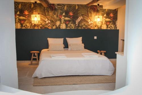 ein Schlafzimmer mit einem großen Bett und einem Gemälde an der Wand in der Unterkunft SUITE AMANTIS évadez vous dans l'univers MYKONOS in Saint-Chamond