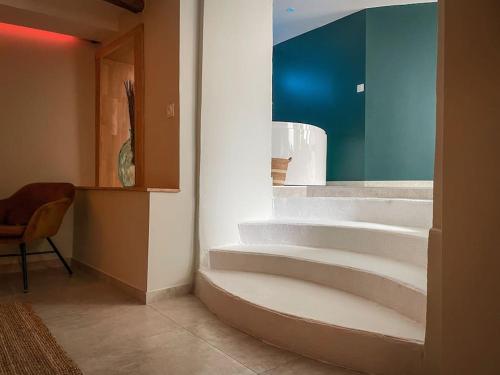 um quarto com escadas e uma cadeira ao lado de uma parede em SUITE AMANTIS évadez vous dans l'univers MYKONOS em Saint-Chamond