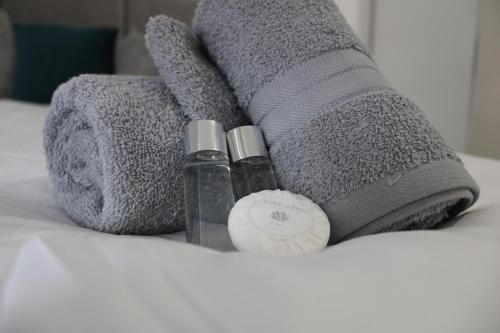 a bed with two bottles of soap and a towel at Beautiful, Spacious, Old Trafford home in Manchester