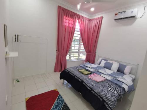 a bedroom with a bed and a window at Nawra Homestay Besut - Free Wifi in Kampung Raja
