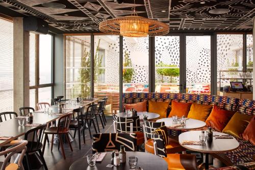 a row of tables and chairs in a restaurant at Mama Shelter Paris La Défense in Puteaux