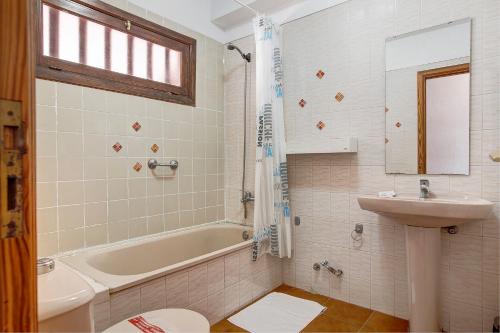Un baño con lavabo, bañera e inodoro. en Garden City, en Costa de Adeje
