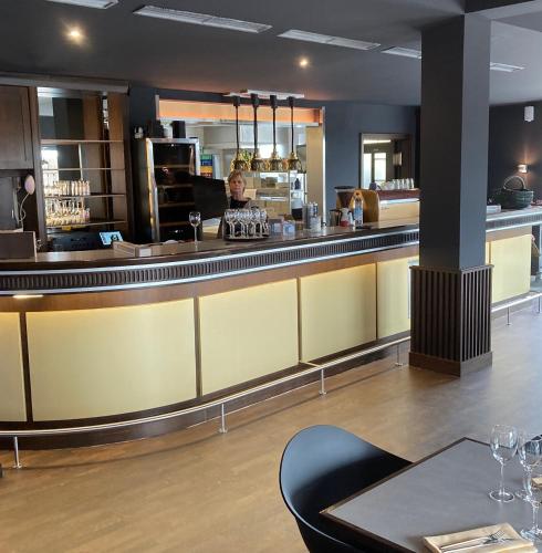 a woman sitting at a bar in a restaurant at Das SinGold Hotel mit Highspeed WLAN und digitalem Schlüssel in Schwabmünchen