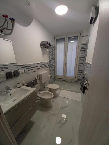 熱那亞的住宿－DOMUS SUPERBA，白色的浴室设有卫生间和水槽。