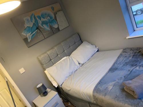 a small bedroom with a bed and a painting on the wall at Kirkby House, 3 bedroom, sleeps up to 7 with sofa bed, holiday, corporate, contractor stays in Kirkby in Ashfield