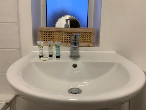 a white sink with two toothbrushes and a mirror at Kirkby House, 3 bedroom, sleeps up to 7 with sofa bed, holiday, corporate, contractor stays in Kirkby in Ashfield