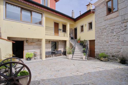a house with a staircase and a stone wall at Casa De Igarei in Igarei