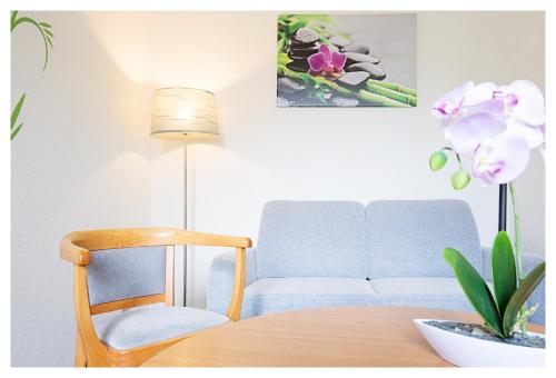 ein Wohnzimmer mit einem Tisch, einem Stuhl und einem Sofa in der Unterkunft Hotel & Restaurant Hähnel in Bannewitz