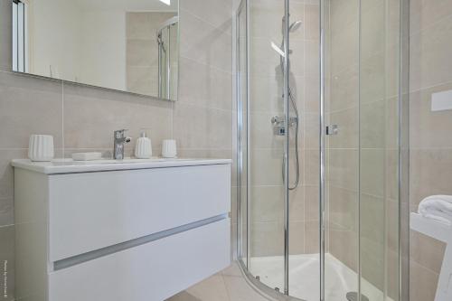 une salle de bain avec une douche en verre et un lavabo dans l'établissement T4 NEUF - JARDIN-TERRASSE ET PISCINE – ACCÈS DIRECT PLAGES ET CENTRE VILLAGE – App C 12, à Saint-Cyr-sur-Mer