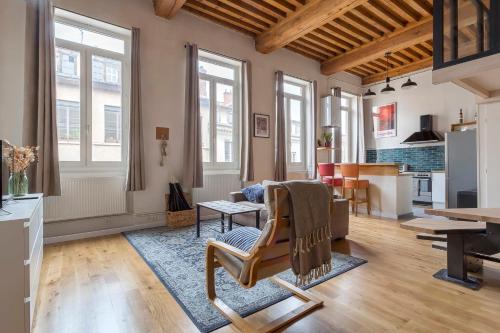 - un salon avec une table, des chaises et des fenêtres dans l'établissement Le Tisserand - Superbe Canut pentes Croix Rousse, à Lyon