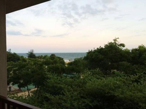 a view of the ocean from a balcony with trees at NIKARA Luxury Beach House in Tissamaharama