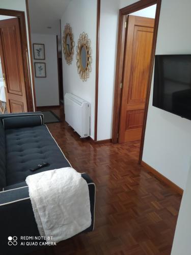 ein Wohnzimmer mit Sofa und Flachbildfernseher in der Unterkunft Habitación Alex , es un quinto sin ascensor in Pontevedra