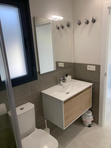 uma casa de banho com um lavatório, um WC e um espelho. em Casa Kadanza em Alhama de Múrcia