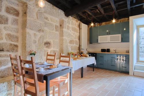 a kitchen with a table and chairs in a room at Casa De Igarei in Igarei