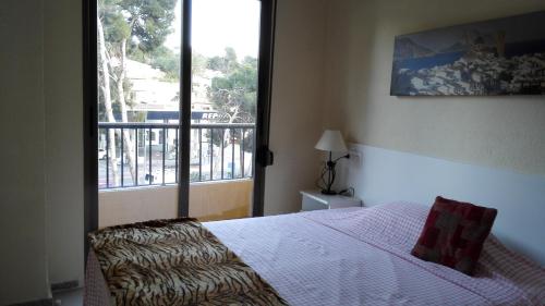 a bedroom with a bed and a large window at Apartamento Tosca Mar in Moraira