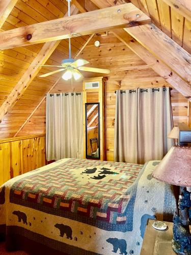 a bedroom with a bed in a wooden cabin at Beary Charming Hottub Great Location 4 Miles to Gatlinburg in Gatlinburg