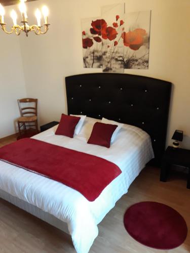 a bedroom with a large bed with a red blanket at La Massonnière Gîte et chambres d'hôtes in Mondion
