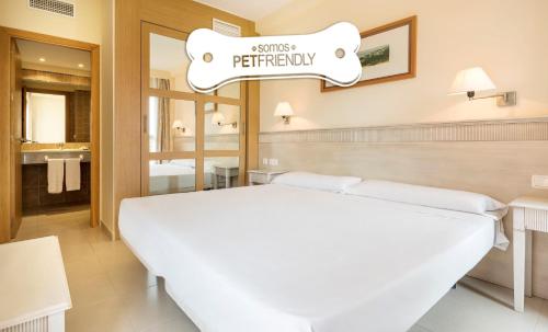 a hotel room with a bed and a sign that reads secrets bathroom at Ilunion Sancti Petri in Chiclana de la Frontera