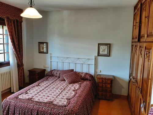 a bedroom with a bed with a red comforter at Apartamento AS CARBALLAS in Caldas de Reis