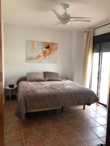 a bedroom with a bed and a ceiling fan at LA CASITA DE EL BOSQUE in El Bosque