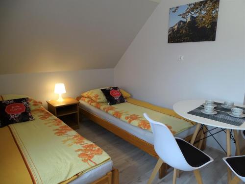 a small room with two beds and a table at Pokoje u Danusi in Sromowce Niżne