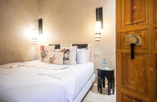 a bedroom with a bed with white sheets and pillows at Riad Houma in Marrakech