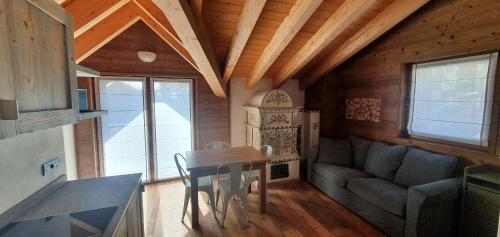 eine Küche und ein Wohnzimmer mit einem Tisch und einem Sofa in der Unterkunft Hotel Paradiso in Livigno