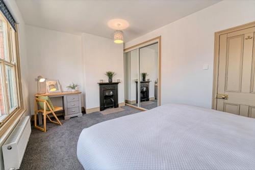 a bedroom with a bed and a desk and a window at Guest Homes - Upper Tything Studio in Worcester