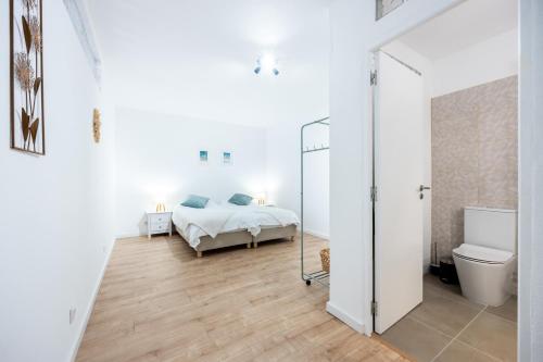 a white bedroom with a bed and a toilet at Fortaleza sea view Villa Miramar - Downstairs Apartment II in Burgau