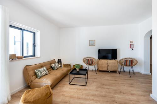 a living room with a couch and a tv at Fortaleza sea view Villa Miramar - Downstairs Apartment II in Burgau