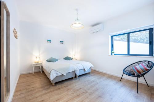 a white bedroom with a bed and a window at Fortaleza sea view Villa Miramar - Downstairs Apartment II in Burgau