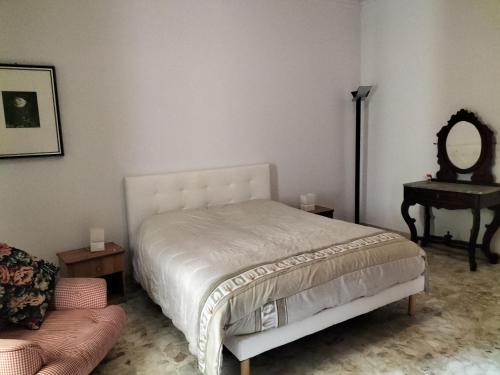 um quarto com uma cama, um espelho e um sofá em Casa del Grillo in centro e nei pressi del mare em Catânia
