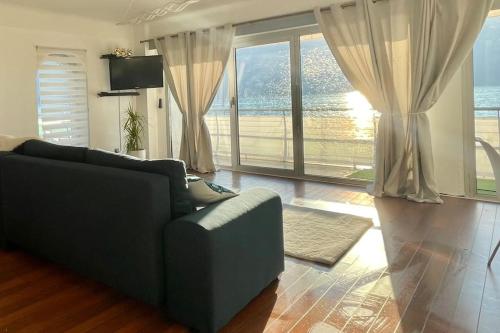 a living room with a couch and a large window at Superbe Appartement avec vue sur le Lac du Bourget in Tresserves