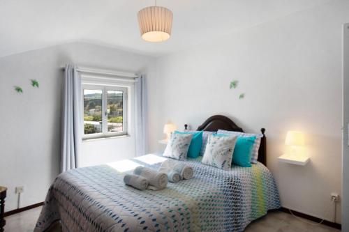 a bedroom with a bed with two stuffed animals on it at Quinta das Andorinhas - Nazaré in Famalicão