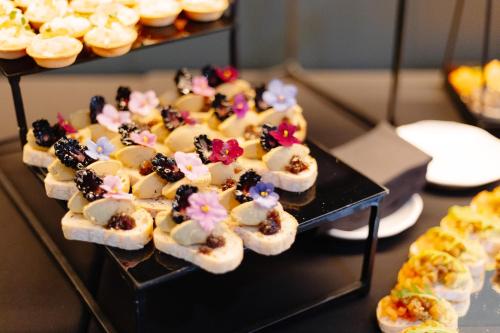a tray of pastries on a table with other desserts at Emily Resort in Lviv